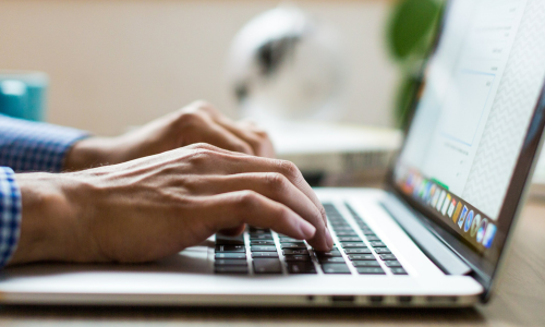 Hands typing on a laptop.